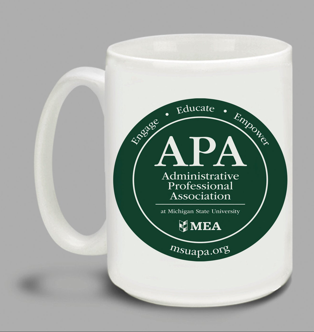 Two white mugs with green 'APA Administrative Professional Association' logos on a gray background.