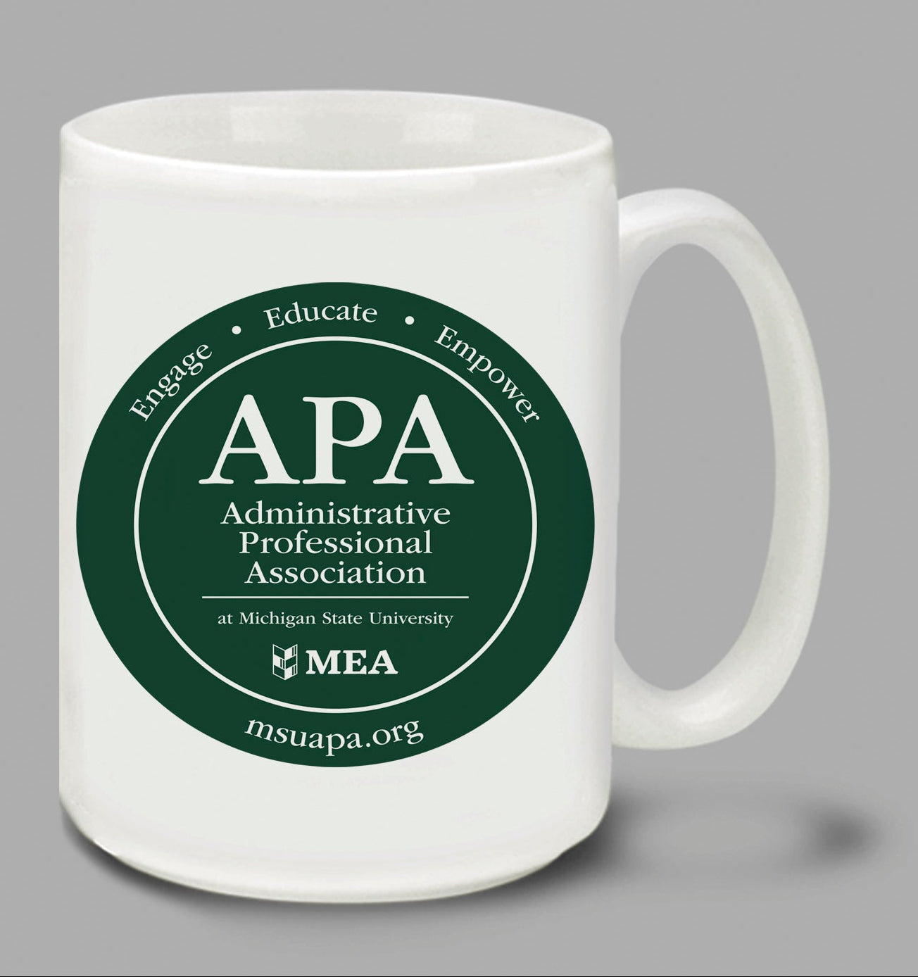 Two white mugs with green 'APA Administrative Professional Association' logos on a gray background.
